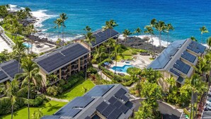 Un resort con varias edificaciones, una piscina y vista al océano.