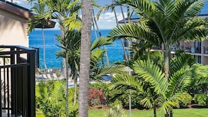 Un resort con piscina, palmeras y vista al océano.