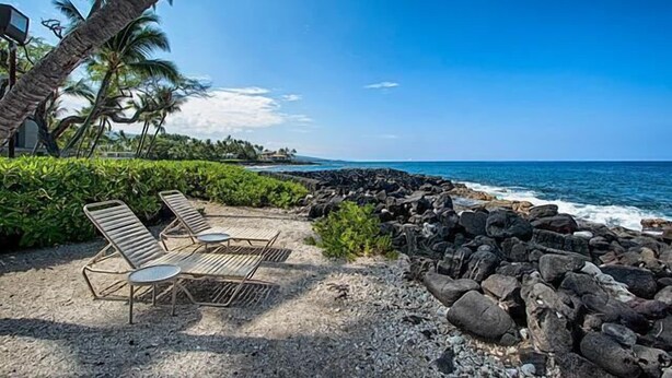 A beach with lounge chairs and a rocky shoreline. - Kona Isle C24 (Kailua-Kona)