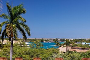 Blick auf die Küste mit blauem Himmel, einer Palme und einem Poolbereich.