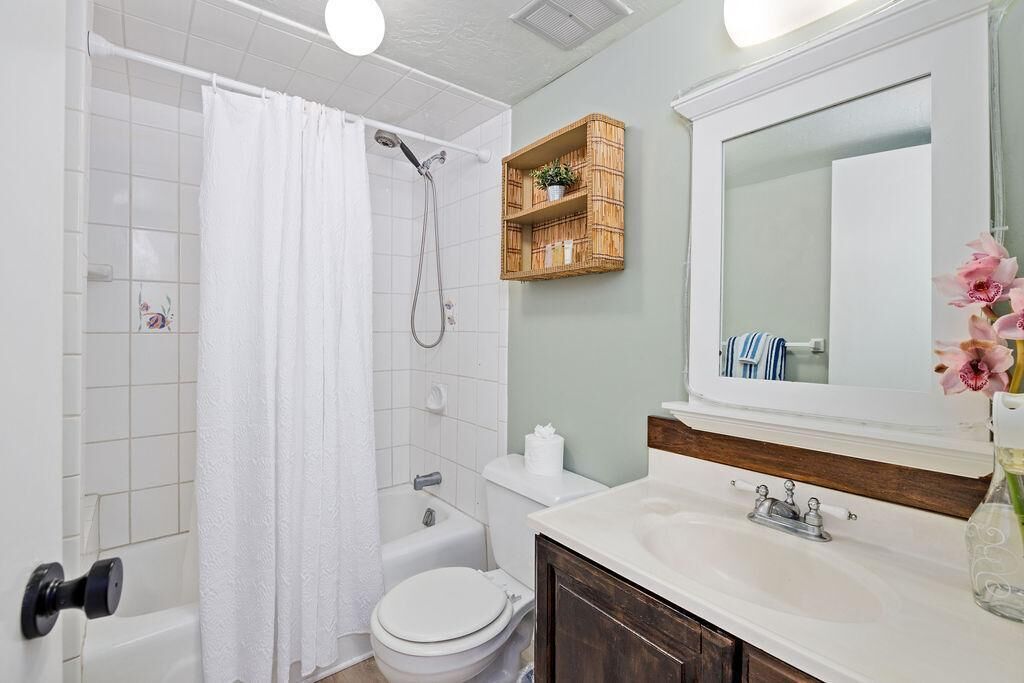 A bathroom with a shower, toilet, and sink.