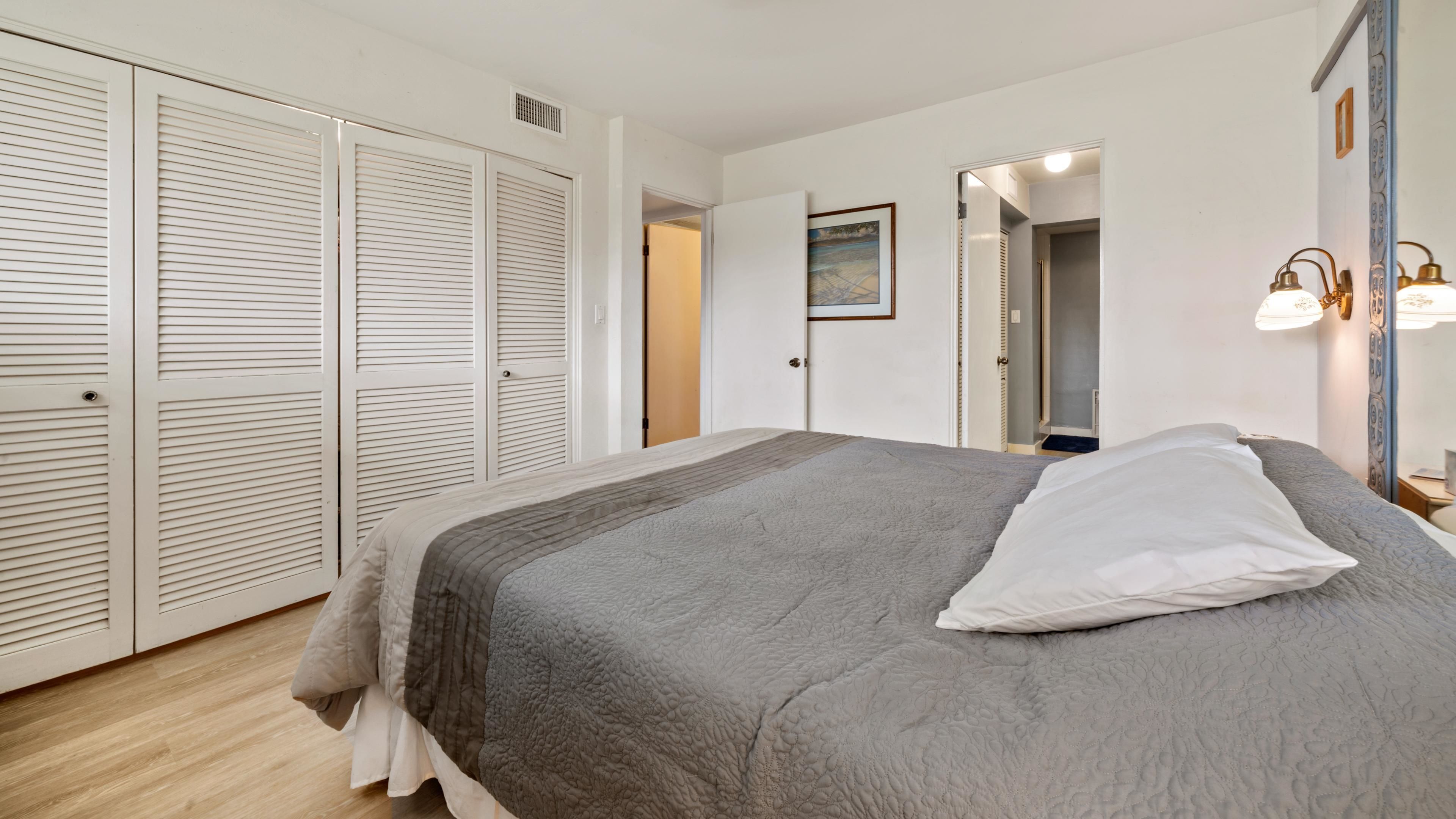 Un dormitorio con cama, armario y espejo.