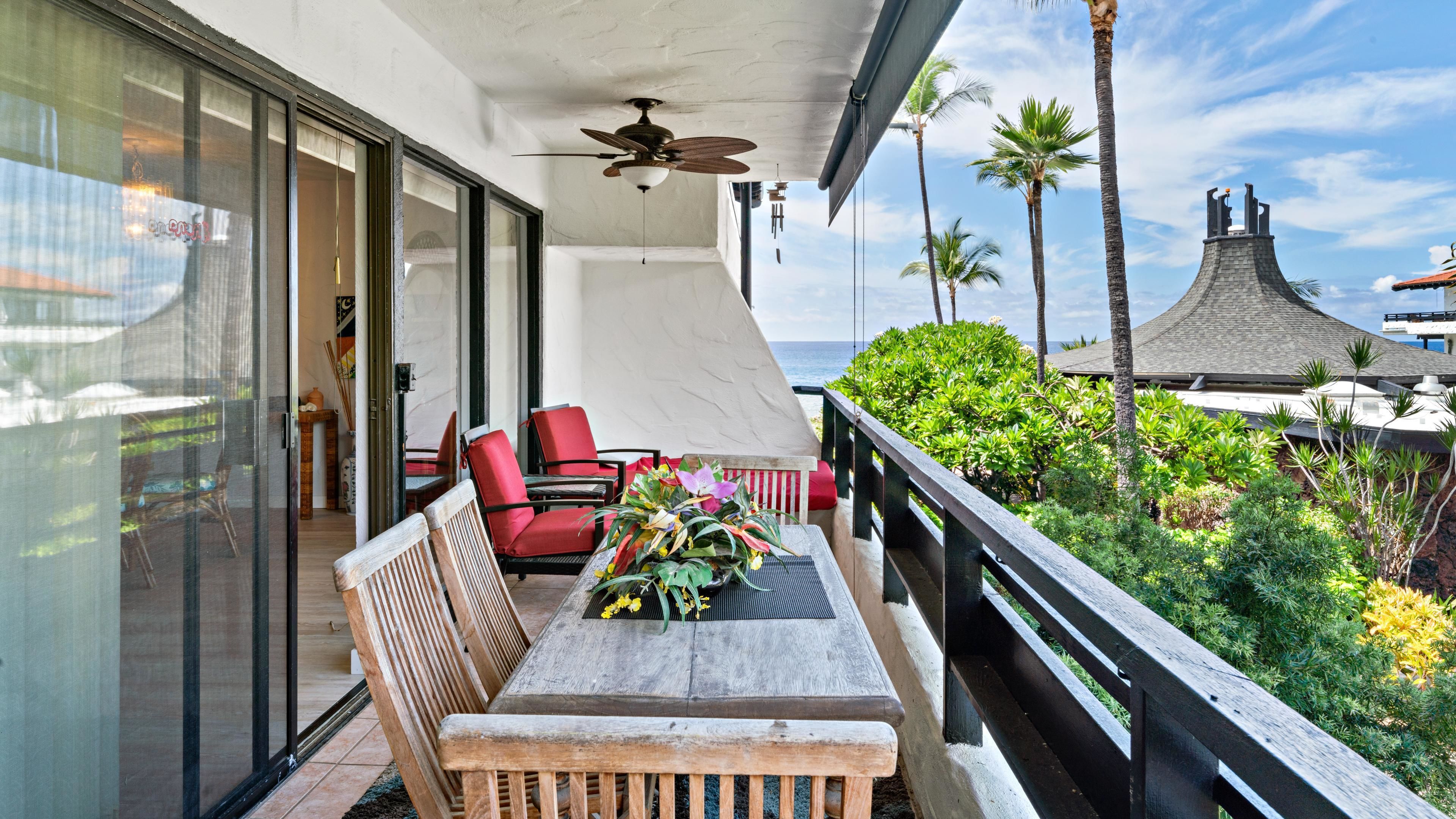 Ein Balkon mit Tisch, Stühlen und Deckenventilator.