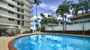 A swimming pool with lounge chairs and palm trees. - Kona Alii 608 (Kailua-Kona)
