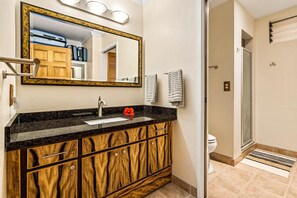 Une salle de bain équipée d’un meuble-lavabo, d’un évier, d’un miroir et d’un porte-serviettes.