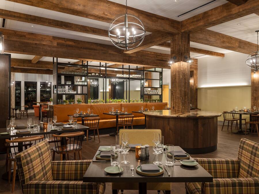 A restaurant with wooden beams, a bar area, and seating arrangements.