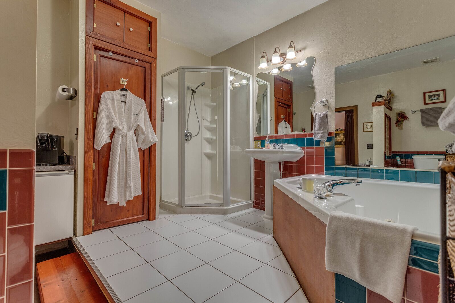 Une salle de bain avec une douche à l’italienne, un lavabo et un miroir.