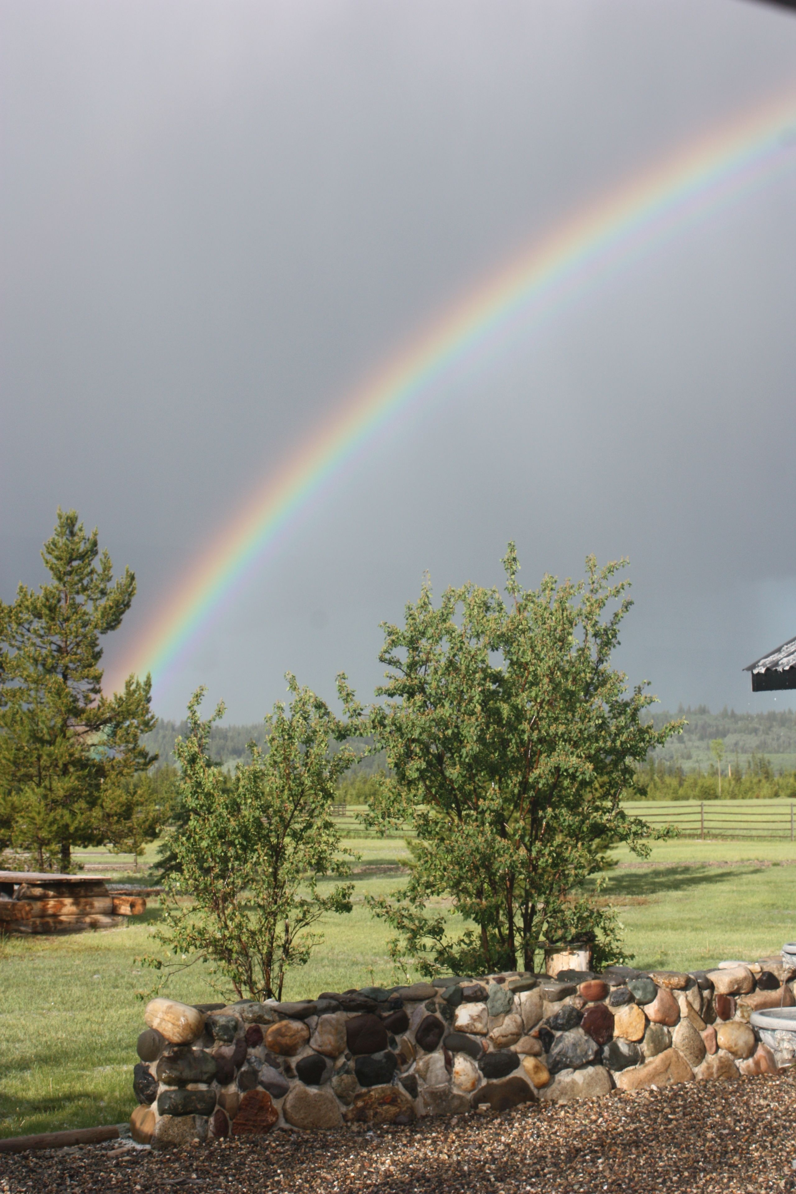 A stone wall with a rainbow in the background.