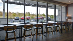A modern interior with large windows overlooking a parking area.