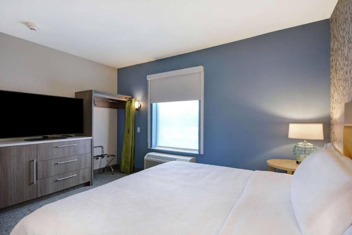 Une chambre d’hôtel avec un lit, une télévision, un bureau et une fenêtre.