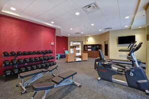 A gym with weightlifting equipment, treadmills, and exercise benches. - Home2 Suites by Hilton Atlanta Marietta (Marietta)