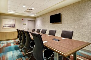 A conference room with a long table, multiple chairs, a flat-screen TV, and a painting on the wall. - Home2 Suites by Hilton Atlanta Marietta (Marietta)