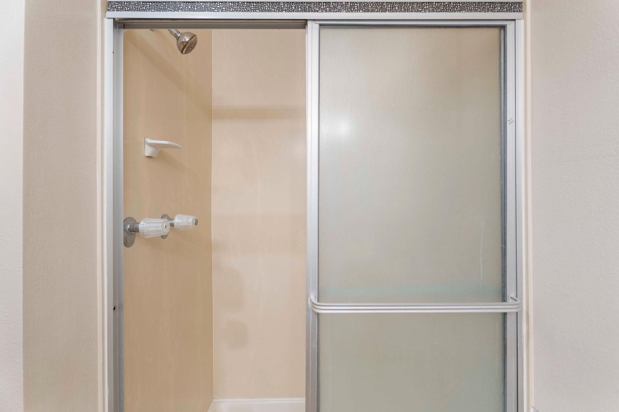 Box doccia con porta in vetro acidato e soffione.