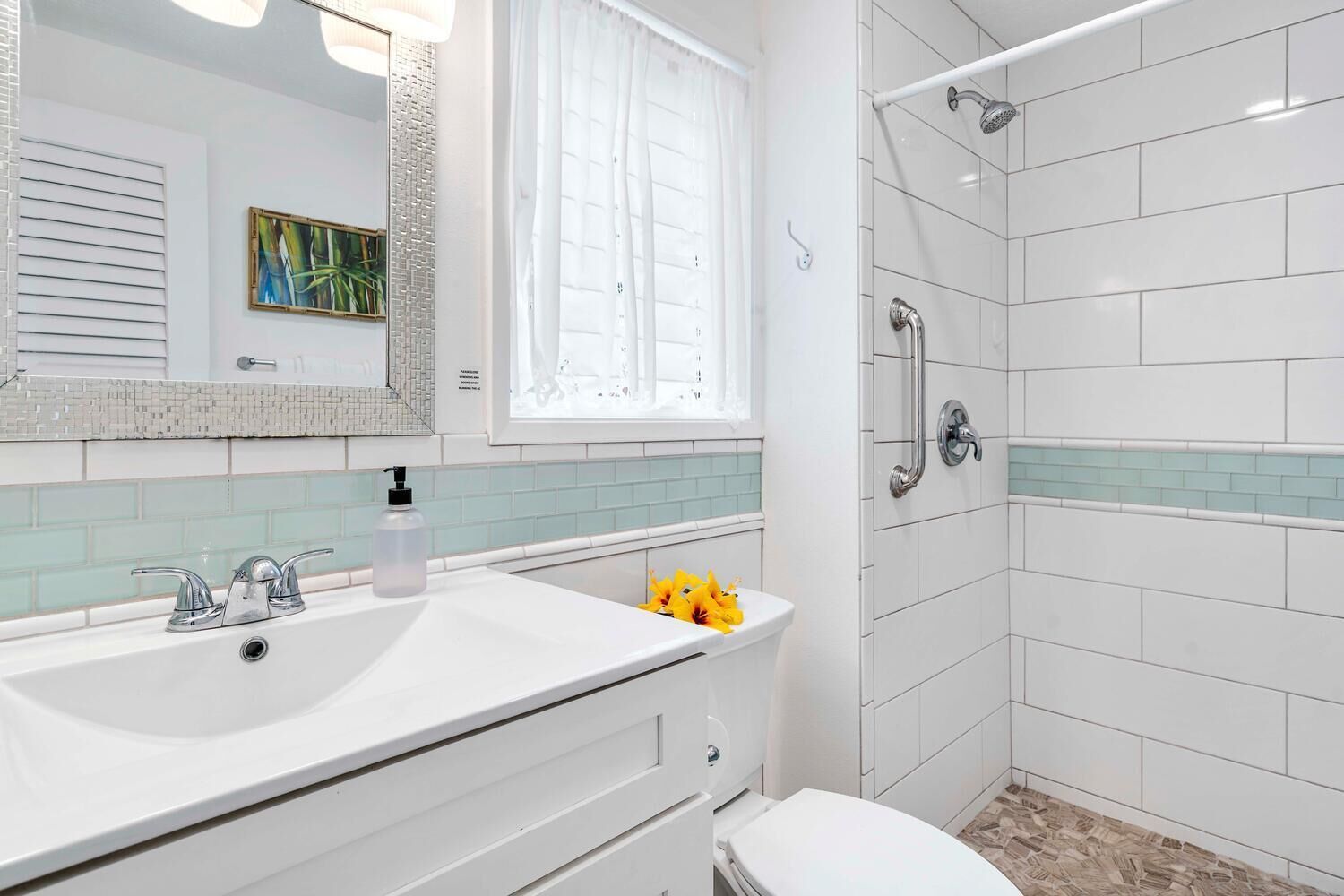 A modern bathroom with a white sink, a toilet, and a shower area.