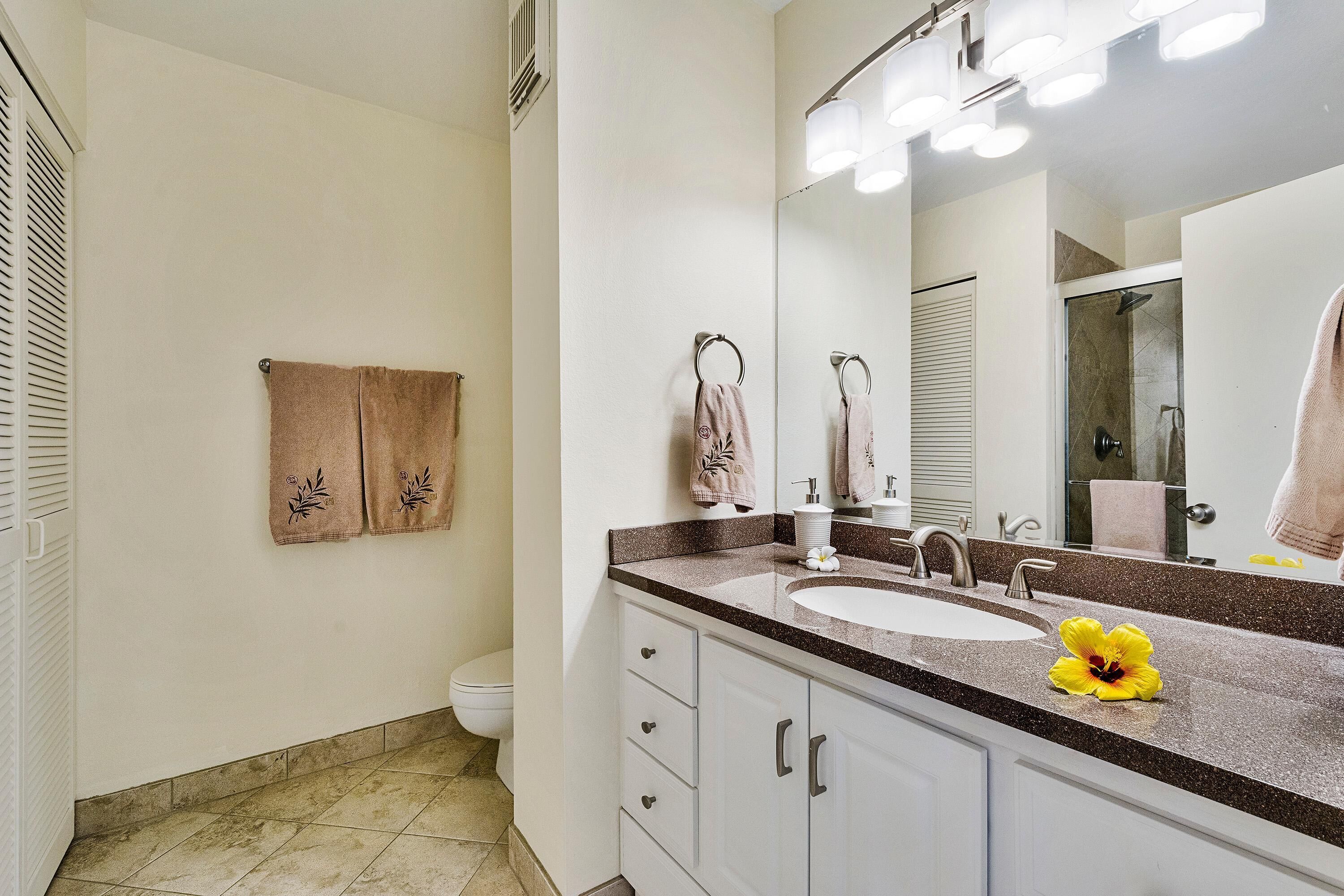 Une salle de bain équipée d’un lavabo, d’un miroir et d’un porte-serviettes.