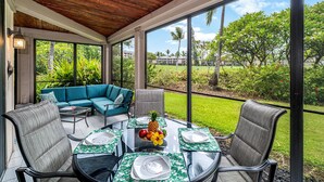 A covered outdoor dining area with a table set for four, surrounded by chairs, and a sofa with cushions. - Keauhou Kona Surf & Racquet Club #6-104 (Kailua-Kona)