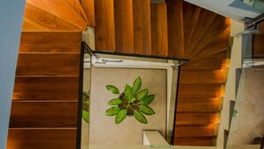 Una escalera moderna con escalones de madera y barandilla de vidrio.