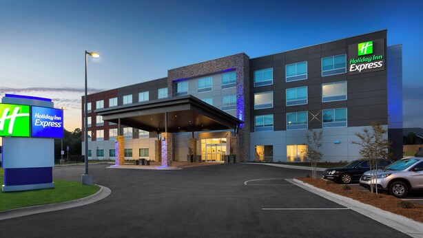 Un hôtel Holiday Inn Express au design moderne, doté d’une entrée abritée et de nombreux espaces de stationnement.