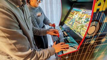 Una persona jugando un videojuego en una consola, con una pantalla que muestra gráficos del juego.
