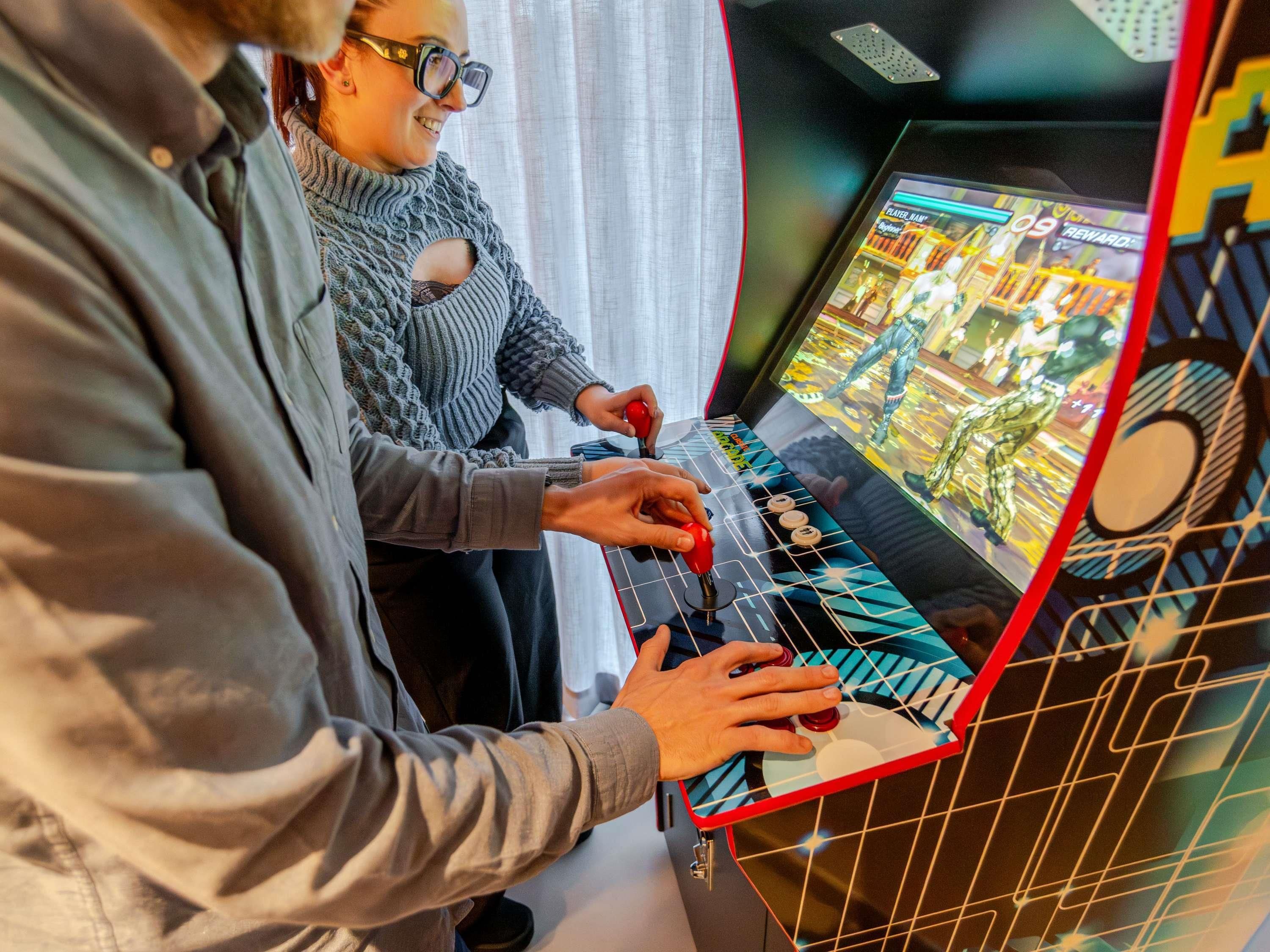 Une personne joue à un jeu vidéo sur une console, et l’écran affiche l’interface du jeu.