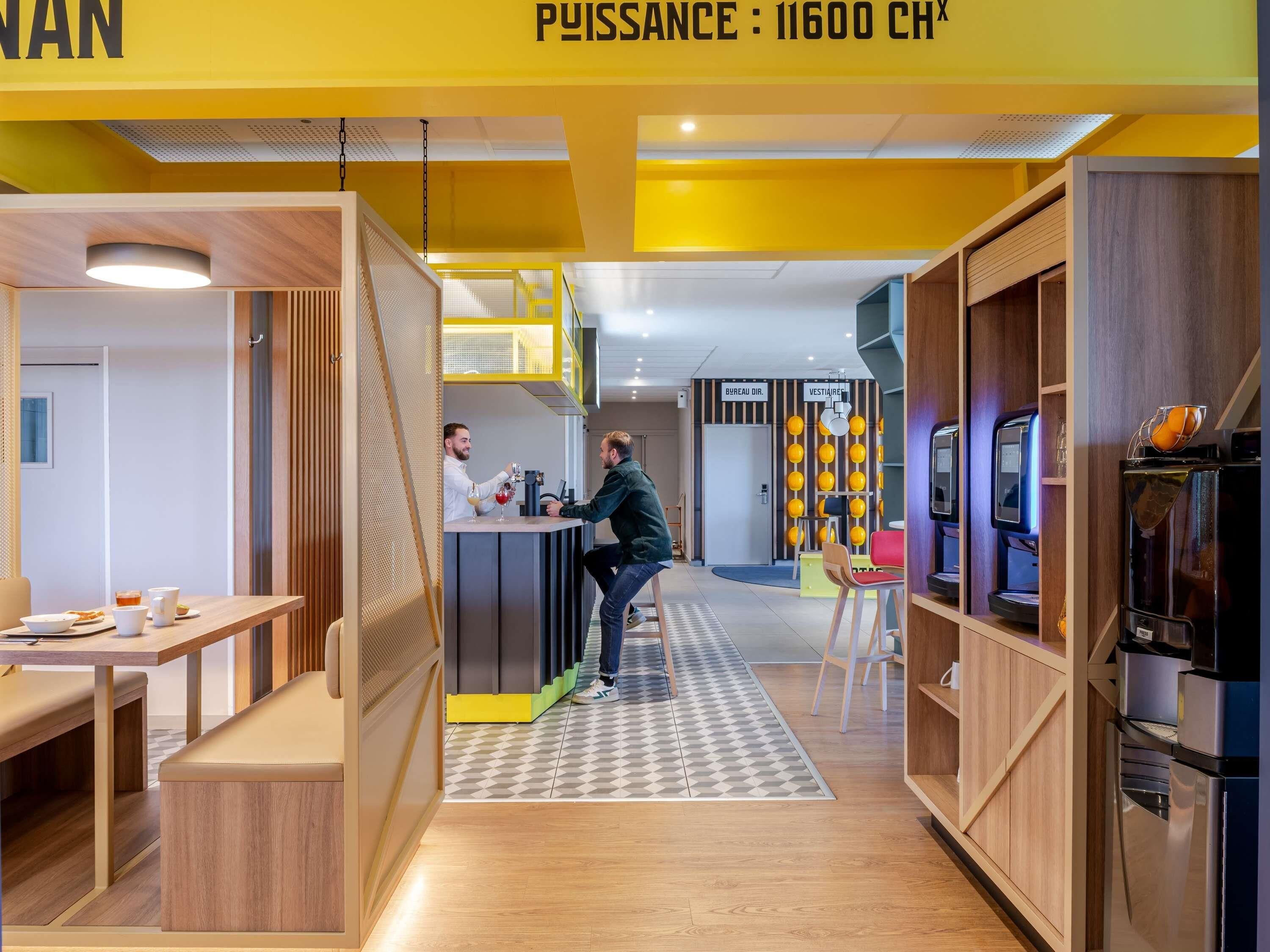 A modern interior with a bar area, seating, and a kitchenette.