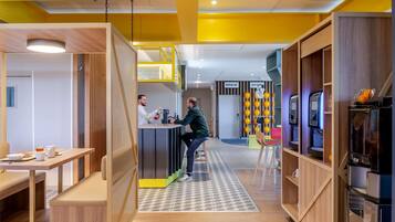 A modern interior with a bar area, seating, and a kitchenette.