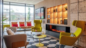Un salon moderne avec une cheminée, un téléviseur et une bibliothèque.