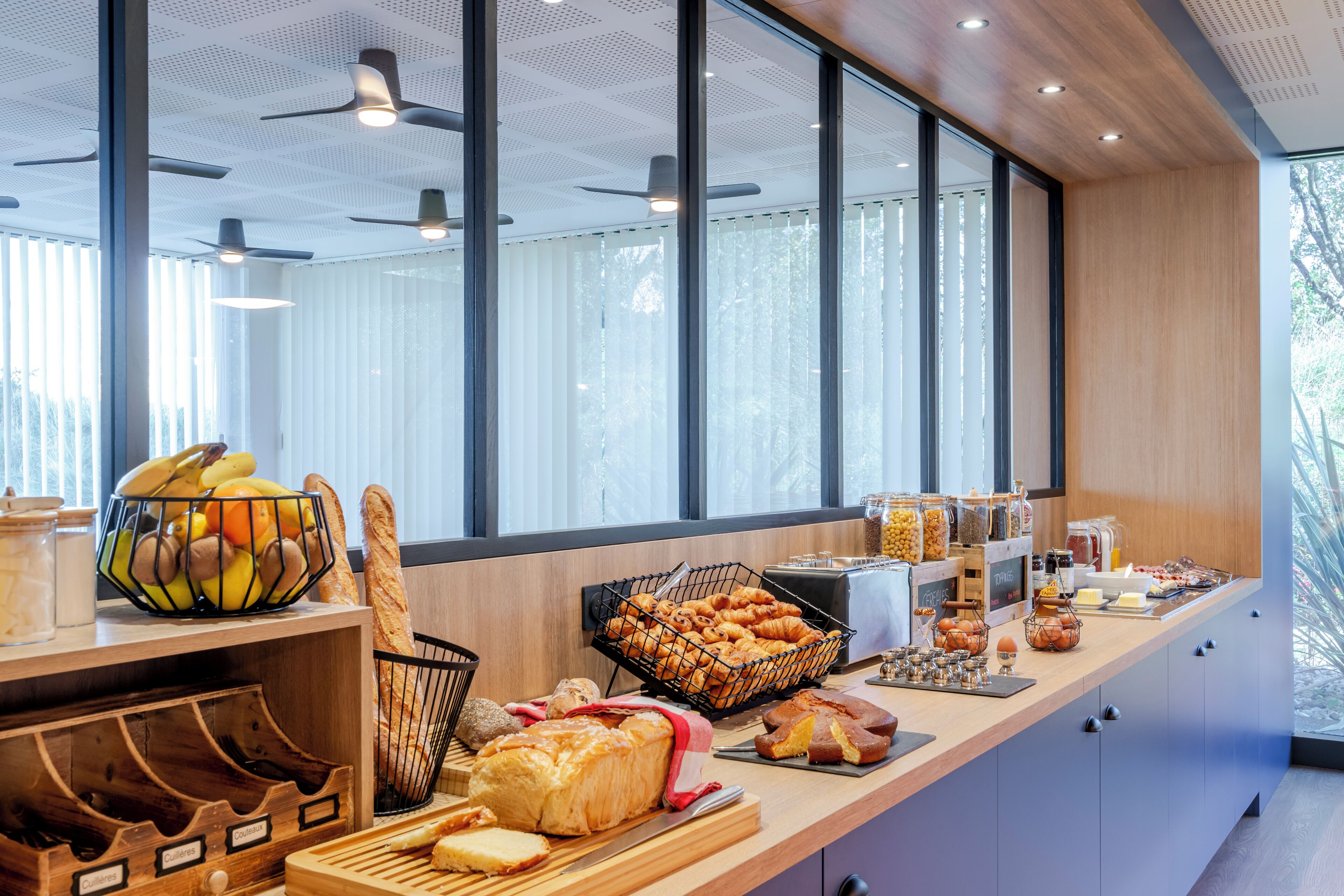 Un bufé de desayuno con panes, pasteles y frutas variados.