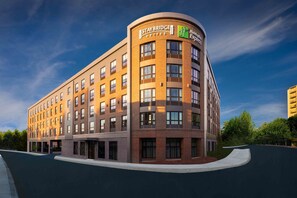 A Staybridge Suites hotel with a curved corner design, multiple floors, and a clear sky. - Staybridge Suites Boston - Quincy by IHG (Quincy)