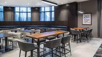 A modern conference room with a long table, multiple chairs, and a seating area.