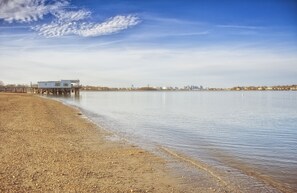 A beach with a pier extending into calm waters, a distant city skyline, and a clear sky. - Staybridge Suites Boston - Quincy by IHG (Quincy)