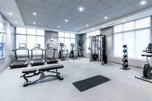 A gym with treadmills, elliptical machines, a bench press, and a squat rack. - Staybridge Suites Boston - Quincy by IHG (Quincy)
