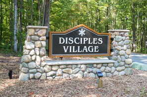 A sign for Disciples Village with a stone structure and a snowflake symbol. - Ski in/out condo on Disciples Ridge- Four bedroom Condo (Boyne Falls)