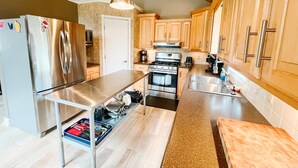 Una cocina moderna con electrodomésticos de acero inoxidable, armarios de madera y encimera de granito.