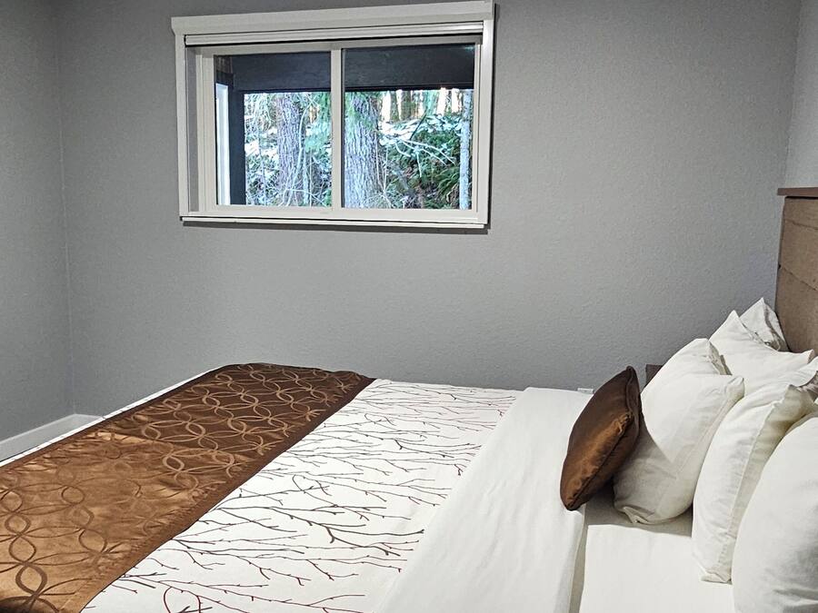 A bedroom with a bed, a window, and a headboard.