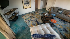 A living room with a sofa, a coffee table, a TV on a stand, and a patterned rug. - Great Rental for Families and Small Groups in Downtown Cabo San Lucas (Cabo San Lucas)