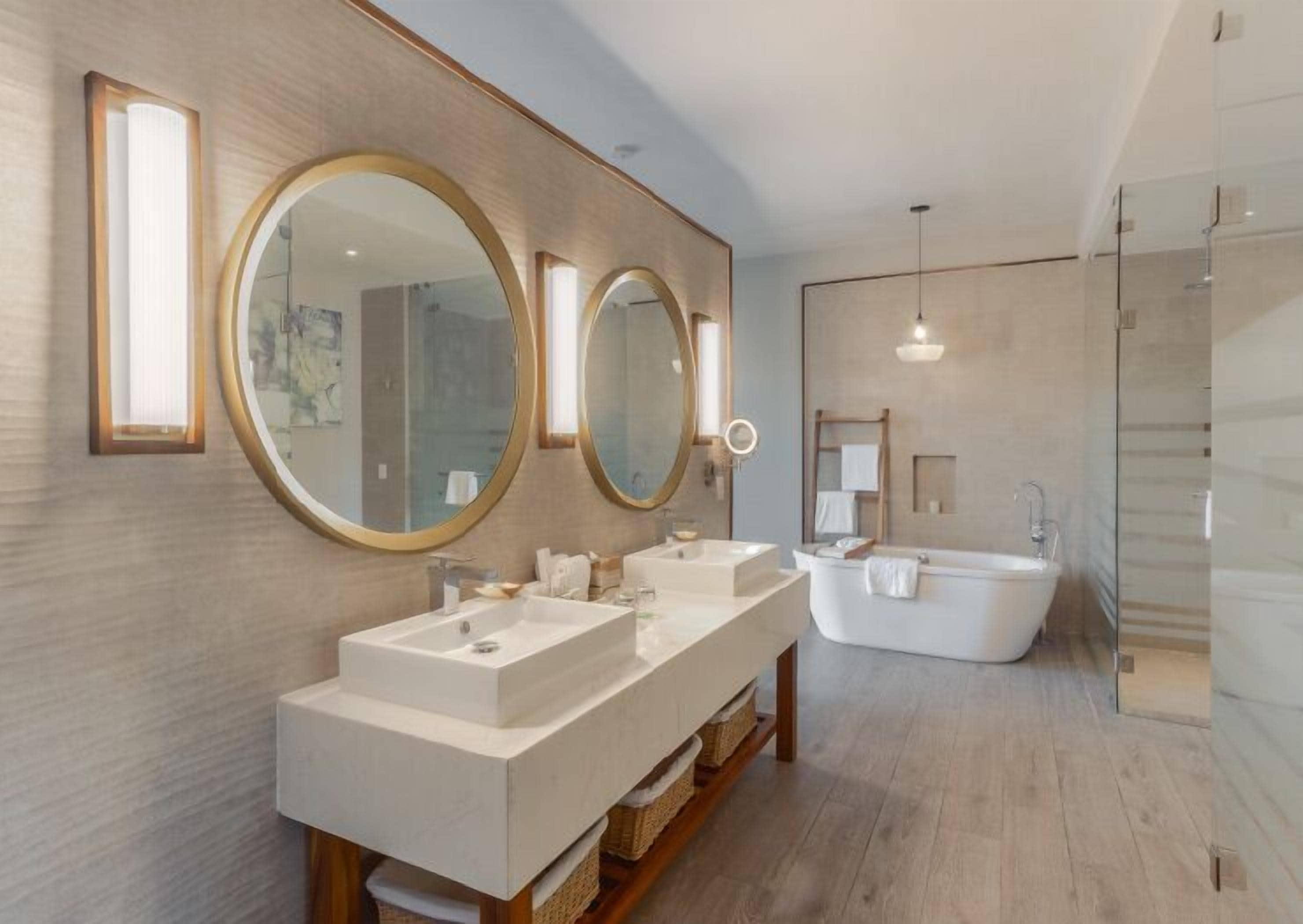 Une salle de bain moderne avec deux vasques, une baignoire sur pieds et trois grands miroirs.