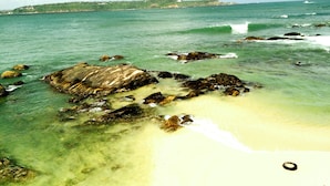 A coastal scene with clear turquoise water, rocky outcrops, and a sandy beach. - Orchard House (Galle)