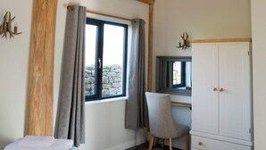 A bedroom with a bed, a desk, and a wardrobe. - Braisty Woods - Knotty & Nice (Harrogate)