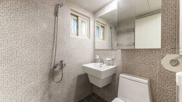 Une salle de bain avec une douche, un lavabo et des toilettes.