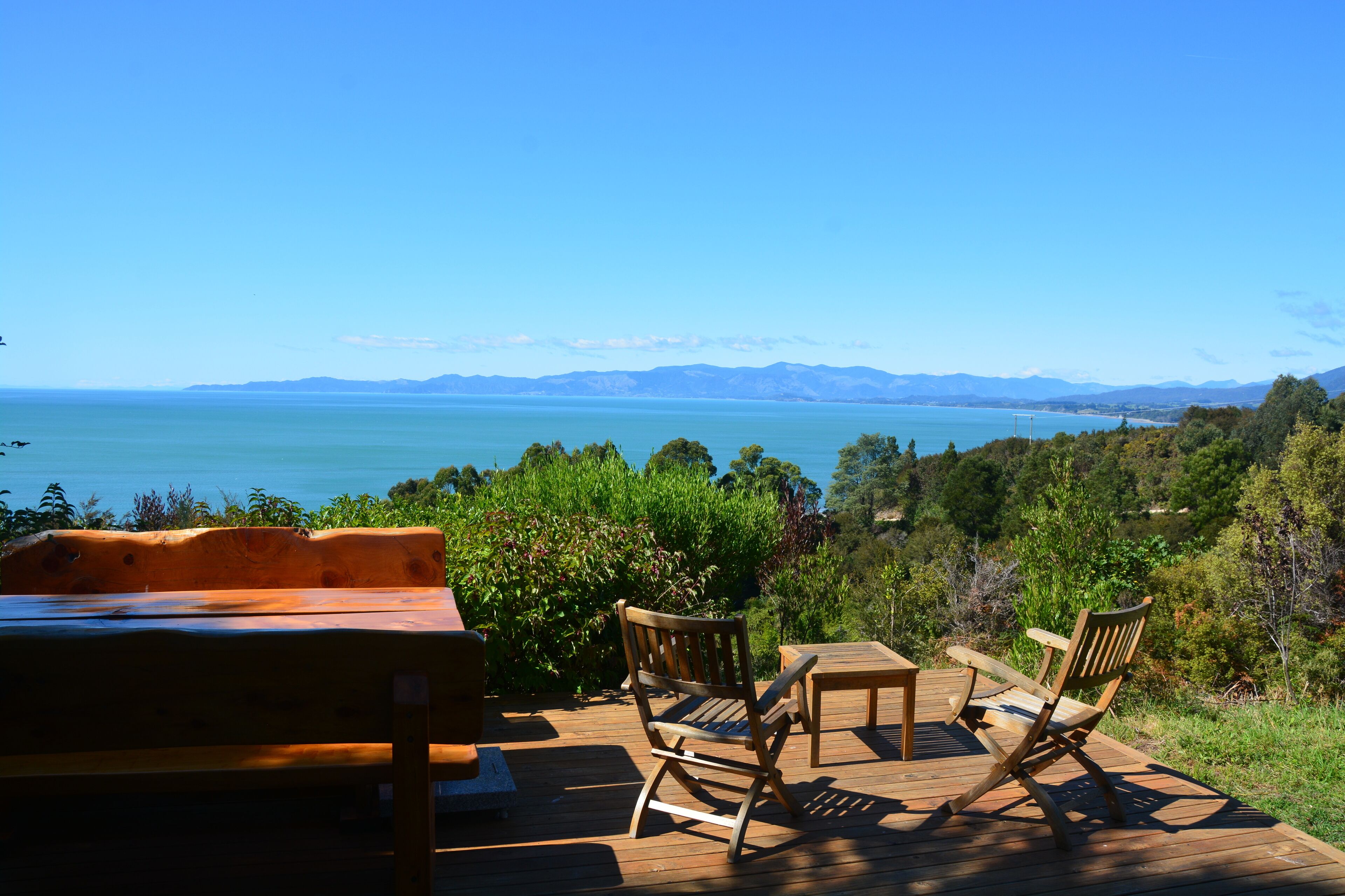 View across Golden Bay from Sundeck - two tables for dining and large BBQ 