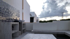 Una terraza moderna en la azotea con un revoque de azulejos, un tazón grande y un diseño minimalista.
