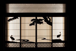 Traditional Japanese shoji screen with a geometric pattern and silhouettes of birds.