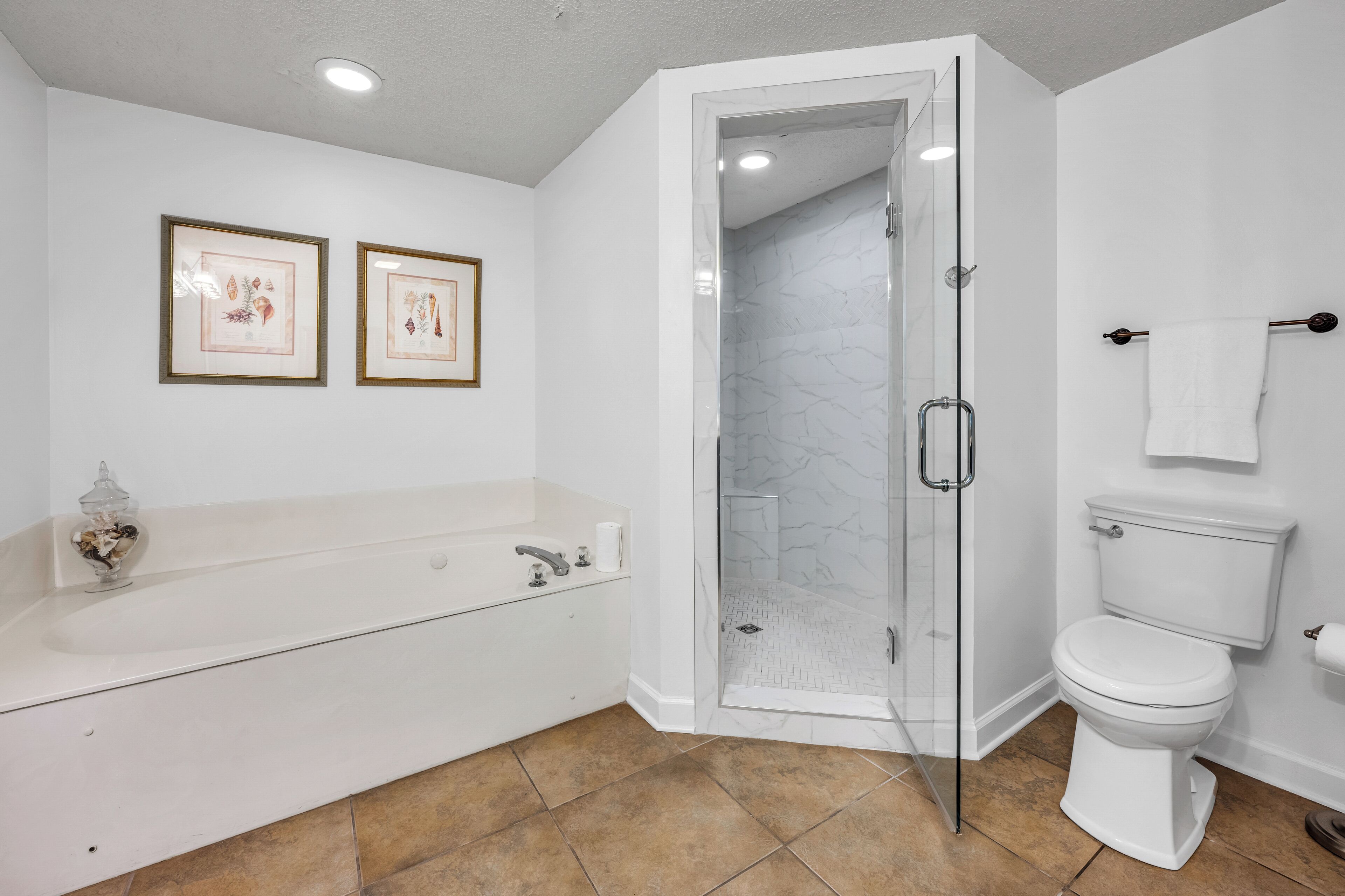 A bathroom with a bathtub, toilet, and glass-enclosed shower.