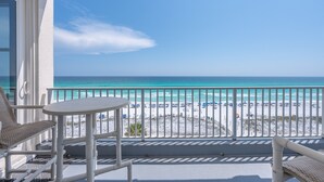 A balcony with a view of a beach and ocean.