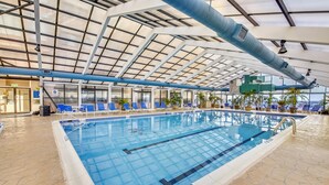 An indoor swimming pool with clear lanes, a tiled floor, and a ceiling with a grid-like structure. - LINENS & DAILY ACTIVITIES INCLUDED*!!! THE CAPRI - 2BR - Ocean View Condo! (Ocean City)