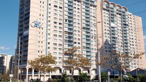 A high-rise hotel with multiple balconies, a prominent sign, and a clear sky. - LINENS & DAILY ACTIVITIES INCLUDED*!!! THE CAPRI - 2BR - Ocean View Condo! (Ocean City)