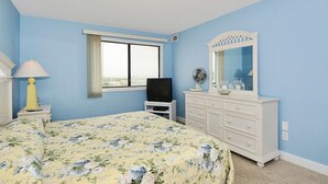 A bedroom with a bed, a dresser, a television, a window, and a mirror. - LINENS & DAILY ACTIVITIES INCLUDED*!!! THE CAPRI - 2BR - Ocean View Condo! (Ocean City)
