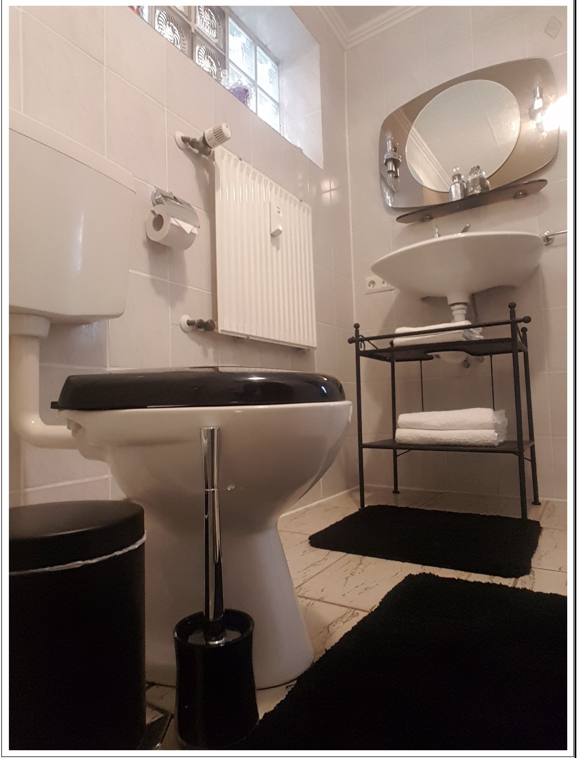 Ein Badezimmer mit Toilette, Bidet, Waschbecken und Handtuchhalter.