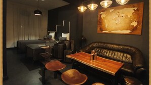 A modern interior with a dining area featuring a wooden table and leather seating, a large abstract painting on the wall, and pendant lighting. - TRAVELLER´S LOUNGE -YOUR HOME NEAR FRANKFURT AIRPORT AND FRANKFURT CITY (Kelsterbach)